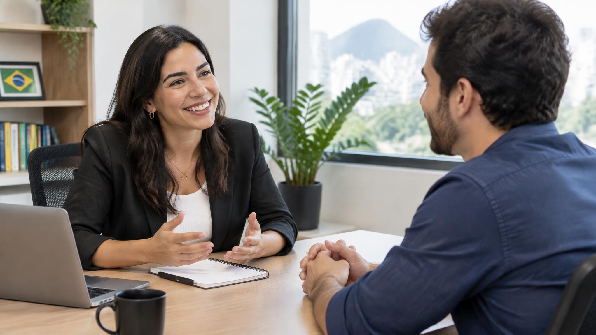 Two people talking across a desk in an office