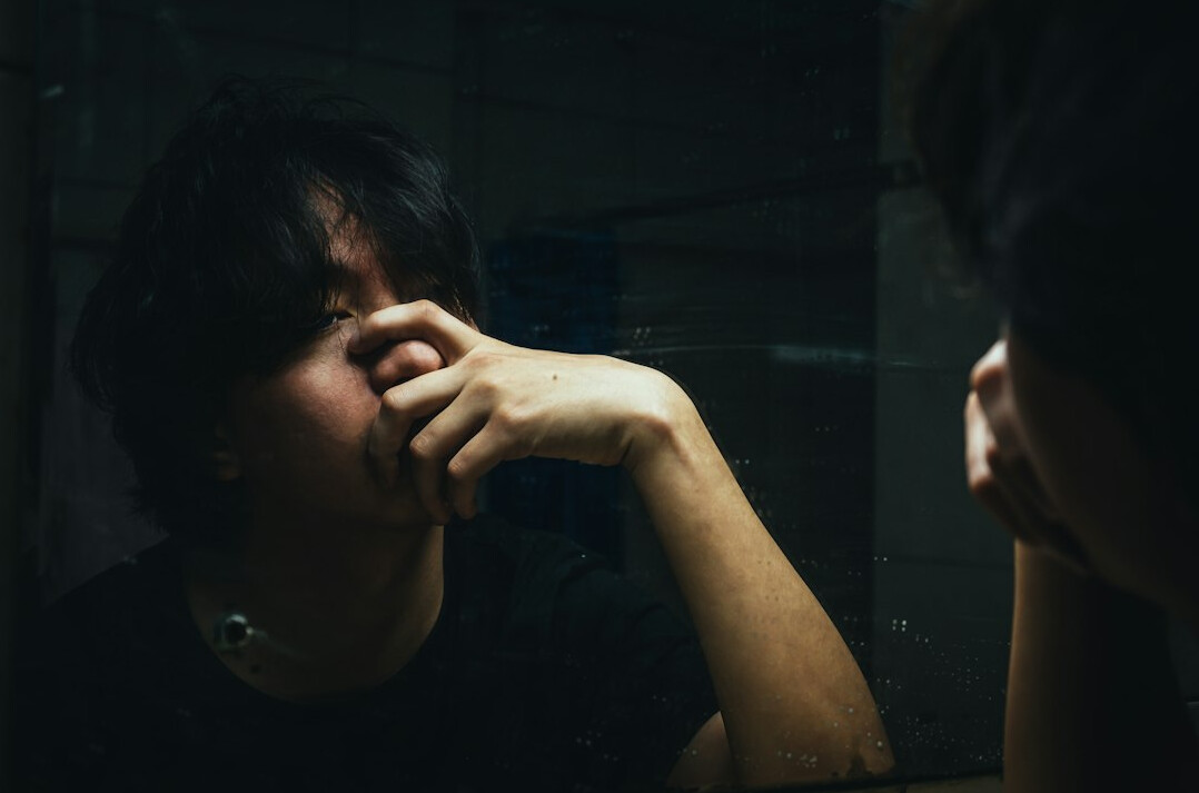 person looking in mirror thoughtfully